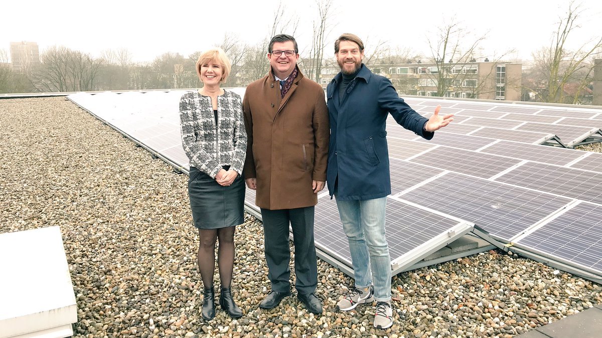 Vlaamse-minister-Bart-Tommelein-midden-op-bezoek-bij-ZonnepanelenDelen-opricher-Sven-Pluut-laat-collectief-zonnedak-Amstelveen-College-zien.jpg